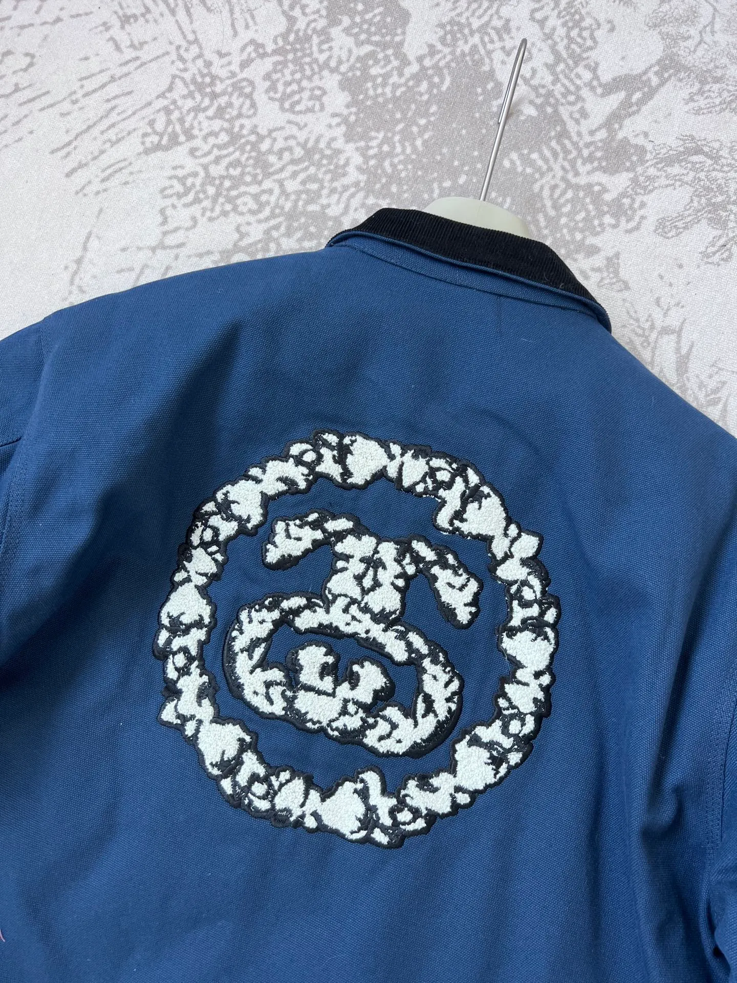 New T66# jacket version 340💰/quilted version 360💰 Stussy x Denim Tears joint model SS25 round chest logo printed zipper opening work jacket, same style for men and women, navy blue Accessories: original dismantling and development, one-to-one customized small labels, collar labels, washing, hang tags, hardware, etc. - Fabric: It is made of the original one-to-one 275g pure cotton fabric, and the high-count double yarn process improves softness and durability. The whole piece is washed, giving it a vintage navy blue distressed texture, echoing the nostalgic tone of the campus theme.   - The collar part is spliced ​​with corduroy or cotton fabrics, which contrasts with the washed cotton of the main body to enhance the visual layering and improve wearing comfort.    - The iconic "Double S + Kapok Ring" combination logo on the back is three-dimensional embroidery. The cotton texture and letter lines stand out in three-dimensionality, enhancing brand recognition.   - A small area of ​​embroidery, card colors and Never Renege slogans are added to the side to echo the cultural theme of the African American community.   - Continuing the short and wide cut of the Detroit work jacket, the cuffs and hem are tightened to give both functionality and practicality.   - The interior adopts quilting technology to provide moderate warmth while maintaining lightness, which is suitable for spring when the temperature difference between morning and evening is large.     - Equipped with YKK metal zipper, it opens and closes smoothly and is durable, and the edge wrapping process improves the overall structural strength.  - African cultural elements: symbols such as the Ace of Spades, the Bid Whist card game scene, and the Jamaican high school area code "718" are integrated into the single product through embroidery, printing and other processes to convey the cultural proposition of Denim Tears.  - Joint logo: Stussy double S logo and Denim Tears kapok ring are combined with embroidery and printing to strengthen the uniqueness of the joint series.  Size: M-2XL M bust 127 length 65.5 sleeve length 61 shoulder width 53.3 [160-165cm 60-70kg] L bust 132 length 66.8 sleeve length 62.2 shoulder width 55.9 [165-170cm 70-85kg] 【170-175cm 80-95kg】 XXL Bust 142.2 Clothes Length 69.3 Sleeve Length 64.8 Shoulder Width 61 【175-180cm 90-105kg】